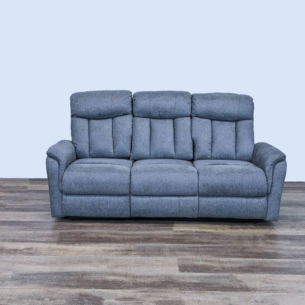 Alt text 1: Gray three-seat Living Spaces reclining sofa with pillowed armrests and back cushioning, front view on a wooden floor.