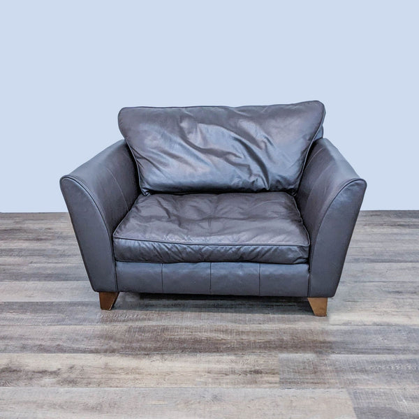 Marks & Spencer contemporary leather lounge chair with wooden feet, front view on wood floor.