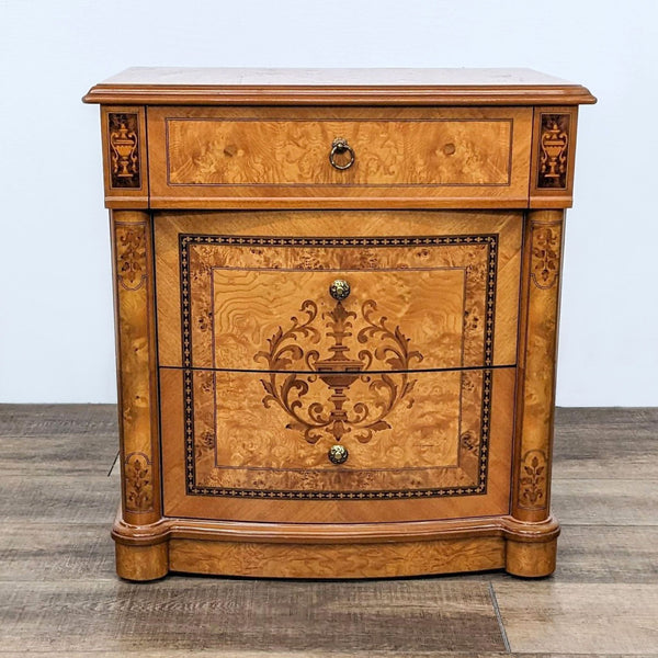 Reperch traditional end table with burlwood drawers, ornate inlay, and metal hardware on a wooden floor.