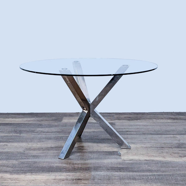 Wayfair dining table with chrome metal crossed-bar base and clear tempered glass top.
