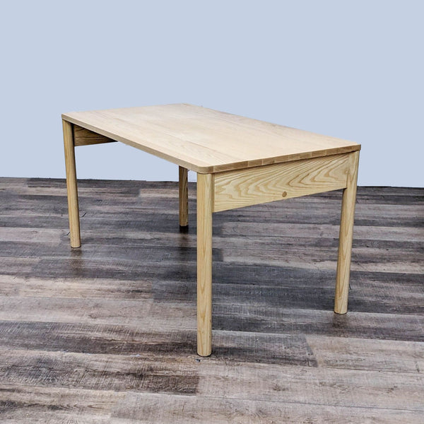 Eave desk by MSDS with a natural wood finish, showing the angled profile on a dark wood floor.
