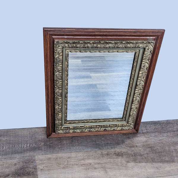 Reperch wooden-framed mirror with detailed ornate designs on border set on a wooden floor against a grey backdrop.