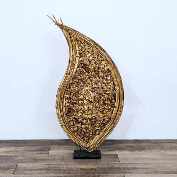 1. Abstract teardrop-shaped sculpture by Reperch, with tightly woven natural materials, on a black stand, against a white wall.