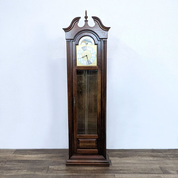 Howard Miller Grandfather Clock, model 610-154, cherry wood with Bordeaux finish, swan neck pediment, and moon phase dial.