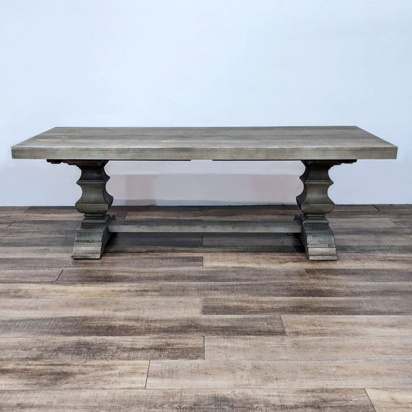 1. Pottery Barn's Banks dining table with thick plank top and baluster posts in gray wash finish, displayed on wood flooring.