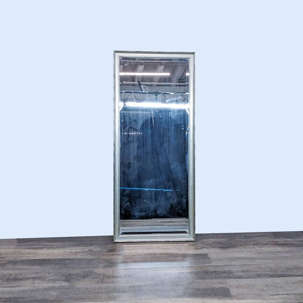 Reperch full-length mirror with silver metallic wood frame, standing on a wooden floor against a white wall.