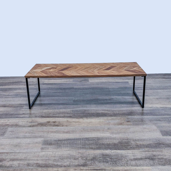 Reperch brand coffee table with a chevron wood pattern top and sleek metal legs against a grey floor.