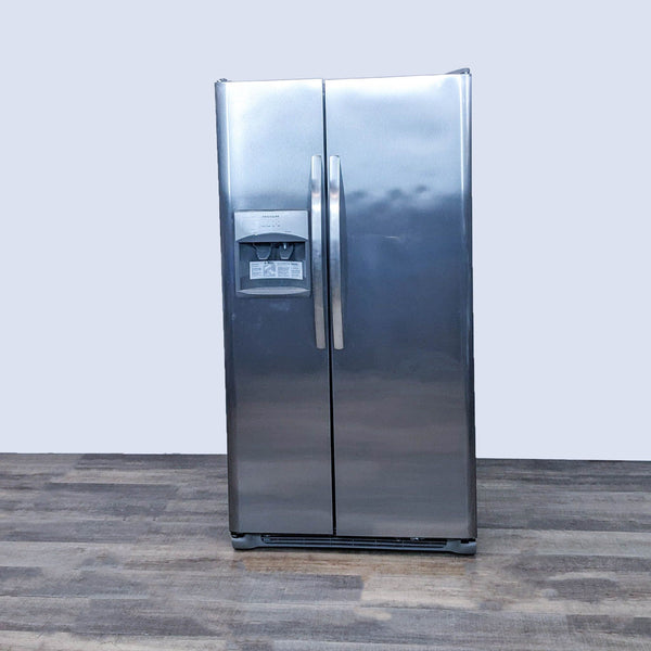 Frigidaire stainless steel side-by-side refrigerator with external water and ice dispenser on a wooden floor.