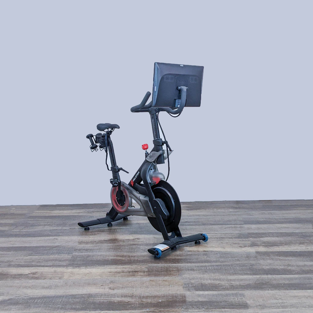 Side view of the Peloton Indoor Exercise Bike highlighting the comfortable seat and touchscreen monitor. Gym Equipment.