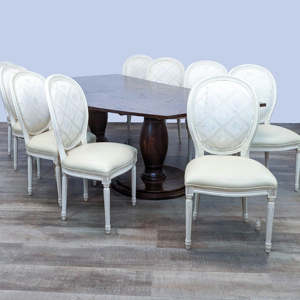 Reperch dining set with dark wooden table with curved edge, double pedestal base, and chairs with white upholstery.