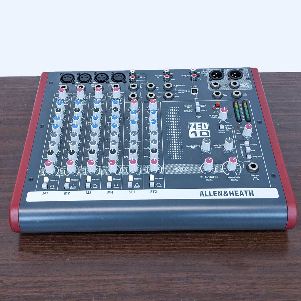 Allen & Heath ZED-10 professional audio mixer on a wooden table, showcasing its control knobs and sliders.