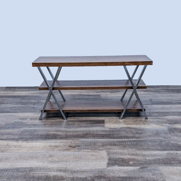 Reperch brand side table with three open wooden shelves, chrome X framework on sides, placed on a wooden floor.