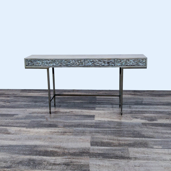 Caracole wood console with closed metallic textured drawers on a metal frame, set on a wooden floor.