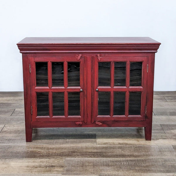 Crate and Barrel red wooden cabinet with glass-paneled doors closed, showcasing timeless design suitable for room décor. (Image 1)
