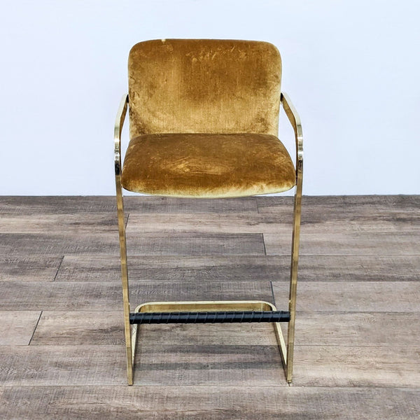 Milo Baughman gold velvet stool with brass metal frame and armrests on wooden floor.