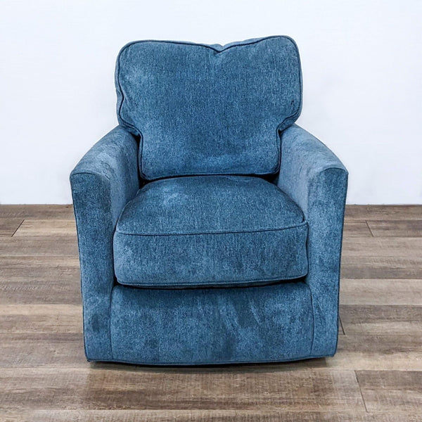 Crate & Barrel Talia chair with a denim-like blue fabric, seen from the front in a room with a wooden floor.