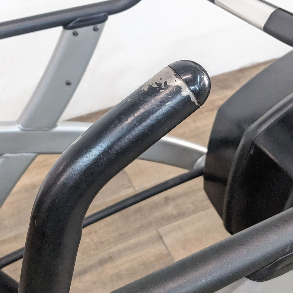 Close-up of wear on the handlebar of a Cybex Arc Trainer, showing signs of use and durability.