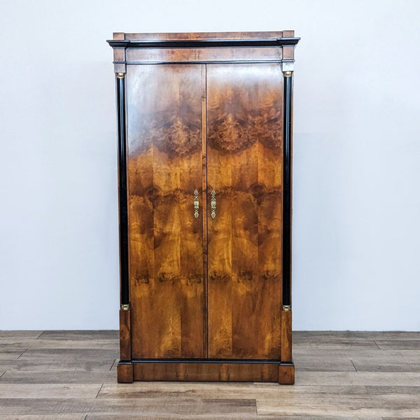 Neo-Classic style Century Furniture burlwood armoire, closed, against a plain wall on wooden floor.
