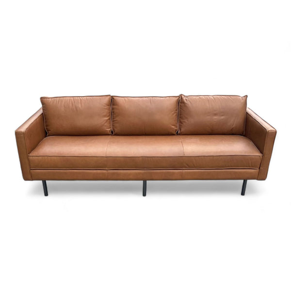 Alt text 1: A Williams-Sonoma 3-seat leather sofa in saddle color, featuring a sleek design with narrow arms and burnished metal feet, isolated on a white background.