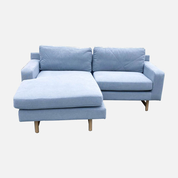 1. Gray West Elm Eddy 3-seat sofa with trestle-style legs and a matching ottoman on a white background.