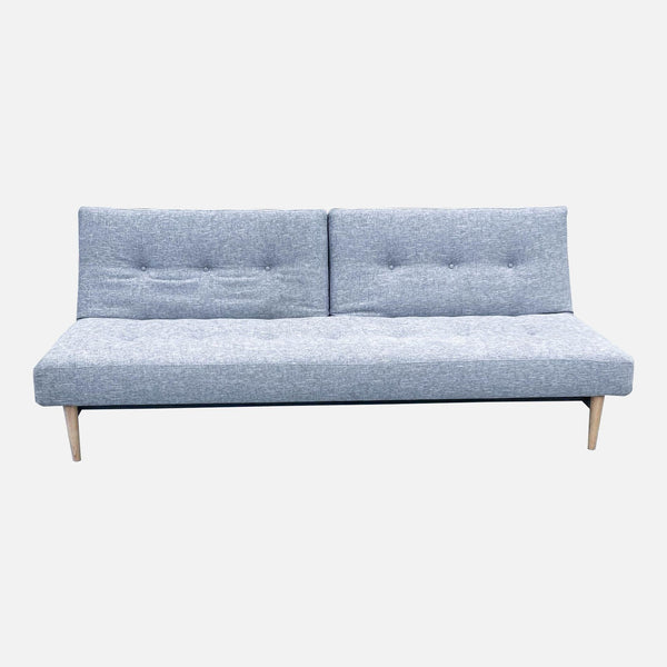Reperch brand compact armless futon in upright sofa position with light gray upholstery and wooden legs.