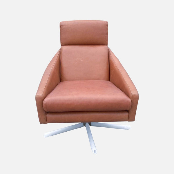West Elm Austin chair with a 360-degree swivel base, upholstered in Chestnut leather with a plush back and faceted arms.