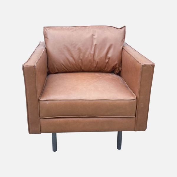 1. "Brown leather chair by West Elm with a modern design, cushioned seat and backrest, placed on a white background."