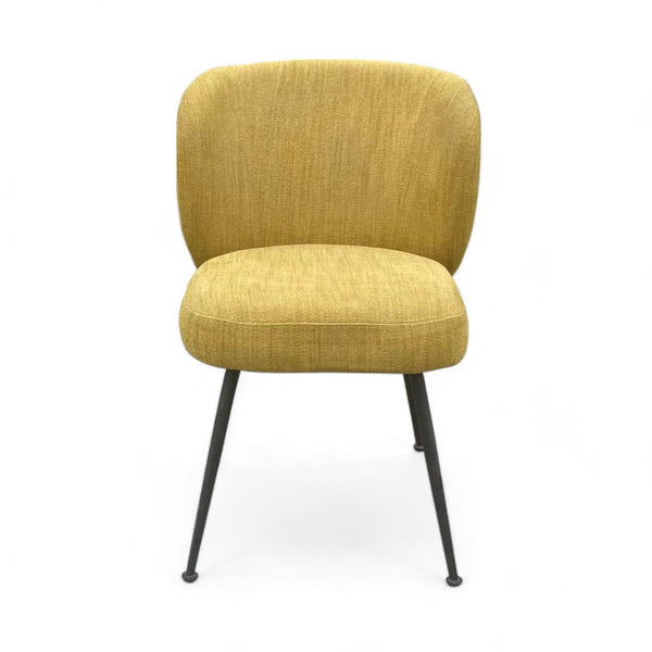 West Elm dining chair with a mustard yellow upholstery and black metal legs on a white background.