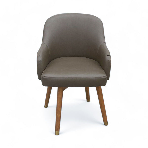 West Elm modern swivel lounge chair with grey upholstery and wood legs with brass caps on a white background.