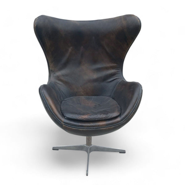 1. "Elegant dark brown leather Reperch swivel lounge chair with a curved backrest on a sturdy metal base."