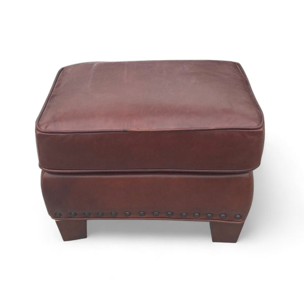 1. Small saddle color leather storage ottoman with nailhead detailing and dark finish feet by Pottery Barn.