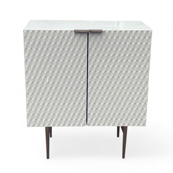 West Elm cabinet with retro textured doors and brass hardware on a white background.