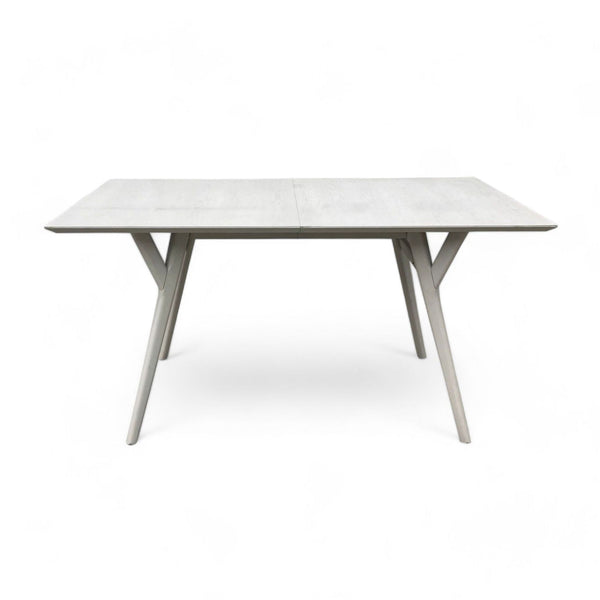 West Elm's Mid Century Expandable dining table with angular A-frame legs and a drop-in leaf for expansion.
