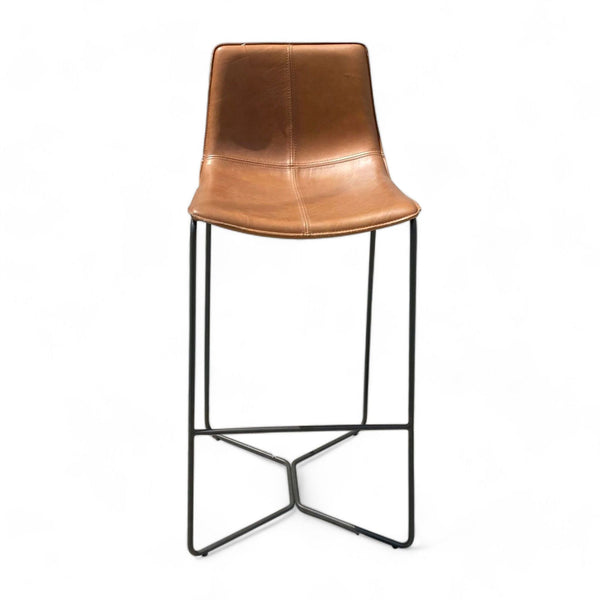 West Elm saddle color leather barstool with comfortable sloped seat on a dark metal frame.