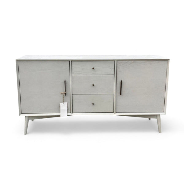 1. West Elm entertainment center with three drawers, light wood finish, and mid-century modern design, closed view.