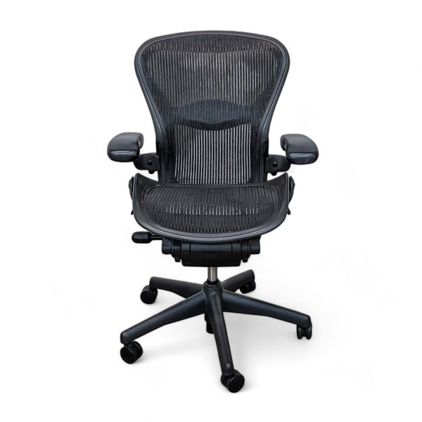 Herman Miller Aeron office chair, Size B, with black mesh, adjustable arms, and tilt, on a white background.