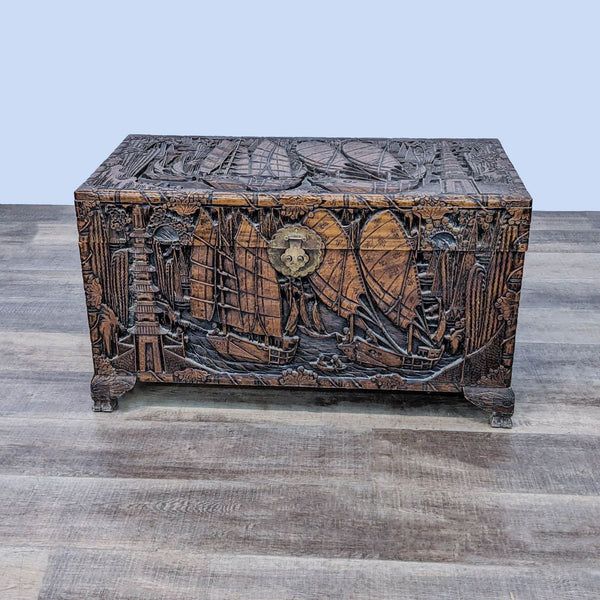 Carved wooden trunk by Reperch with nautical theme, ships, and intricate details, displayed on a wooden floor.