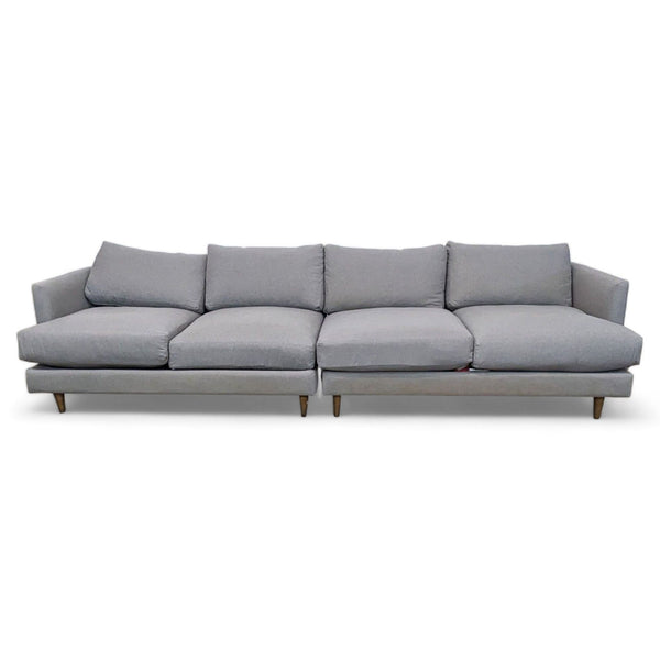 1. Gray three-piece fabric sectional by Living Spaces with narrow arms and tapered legs, configurable as an L-shape or large sofa.