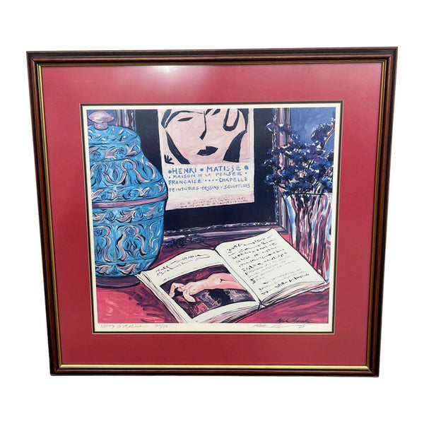 Print of "Homage to Matisse" by Michele Richard Kennedy in a red frame, featuring a vase, portrait, and book.