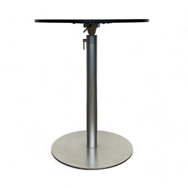 Lapalma Brio dining table with round wooden top and single metal pedestal on a plain background.