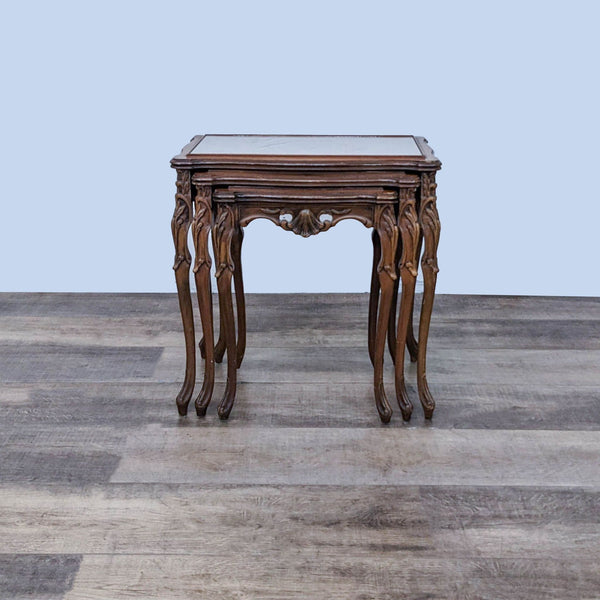 Reperch end table with ornate cabriole legs and glass top, against a wooden floor.