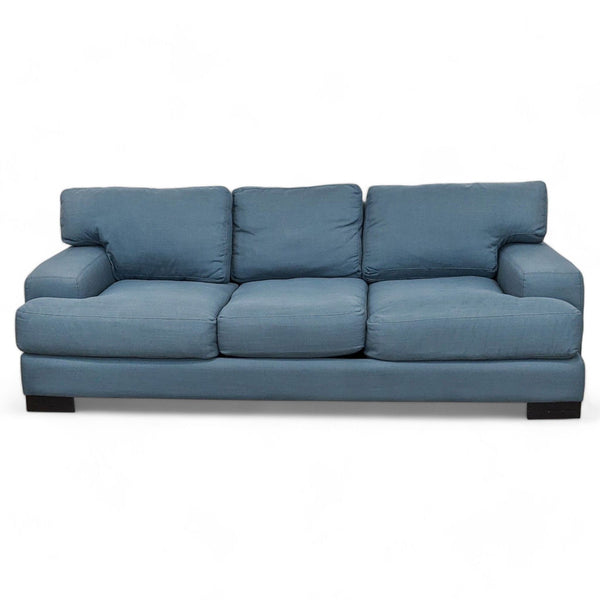 1. Blue slate fabric upholstered 92" Living Spaces sofa with plush back cushions and dark wood feet isolated on a white background.