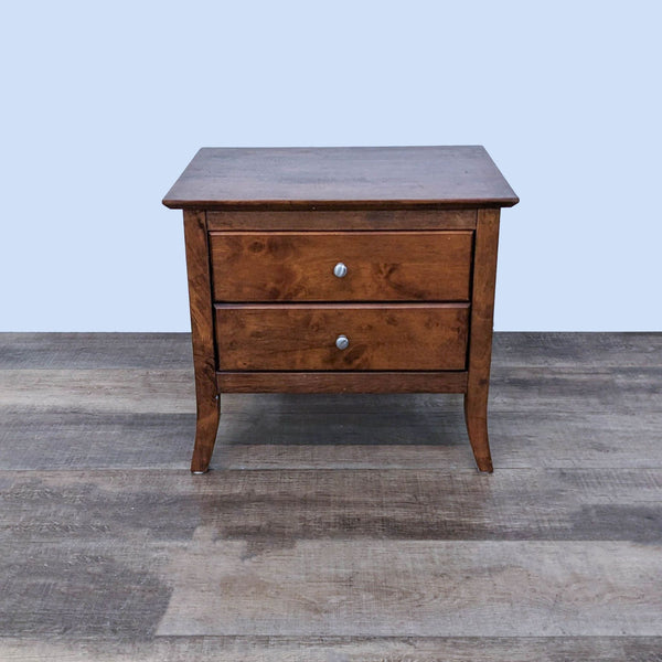 Reperch end table on wooden floor, closed drawers, side view, against a plain background.