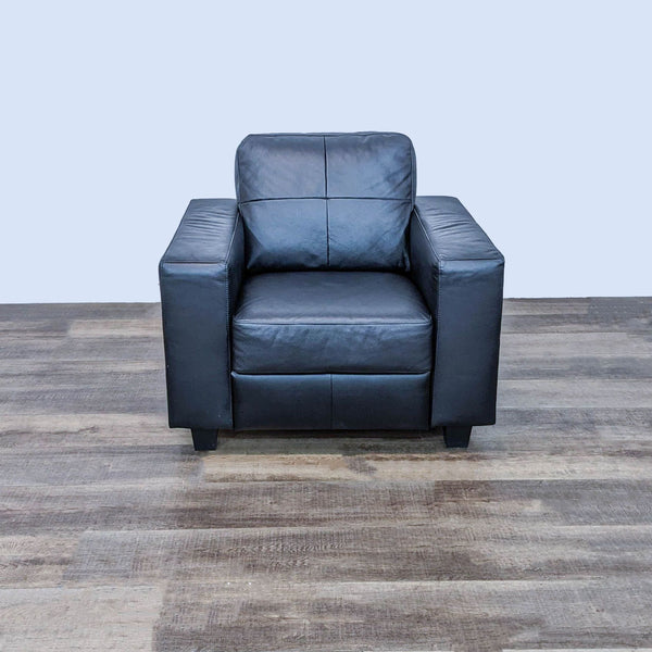 IKEA Skogaby club chair with black faux leather and block feet, front view on a wooden floor.