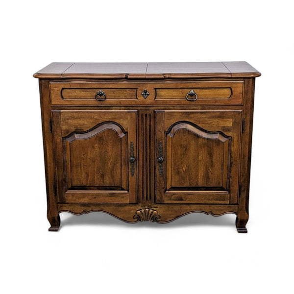 Ethan Allen wooden sideboard with carved details and closed doors on a white background.