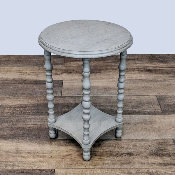 1. Ethan Allen round side table with turned legs and lower shelf, finished in grey on a wood floor.