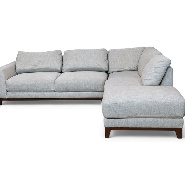 Reperch-brand modern gray sectional with chaise lounge and tapered wooden legs.