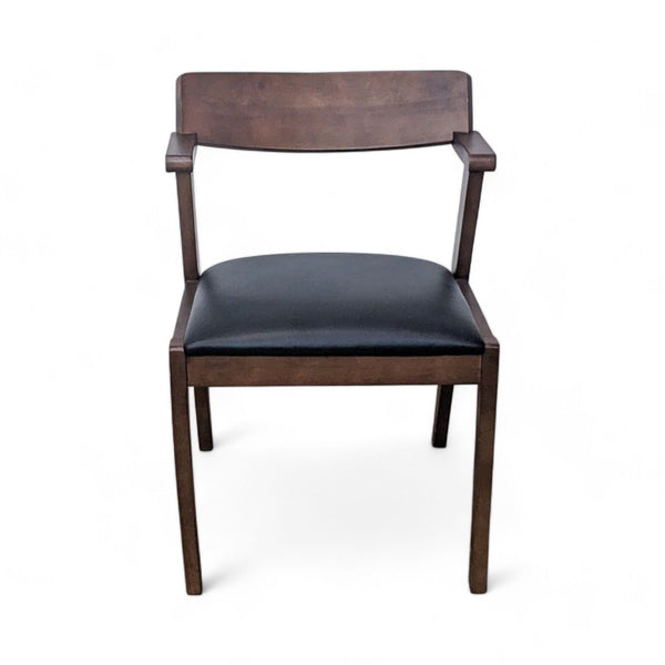 Modern Article Zola dining chair with curved wooden backrest and black leather padded seat.