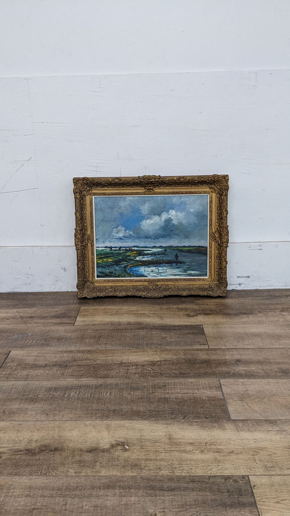 3. Vintage Reperch beach landscape oil painting with dark clouds and coastal scene, framed in decorative gold, standing on wooden floor.