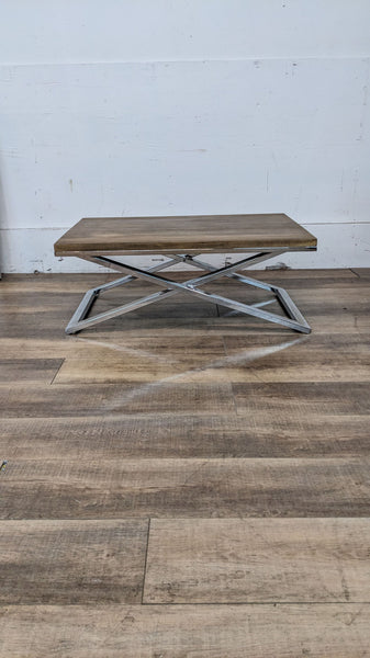 Alt text 1: Cost Plus metal X-base coffee table, tarnished metal visible, with missing screws on wooden top, against a white wall.